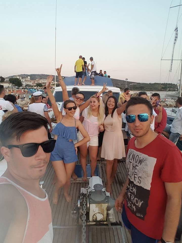 Friends celebrating together on the deck of a boat at sunset