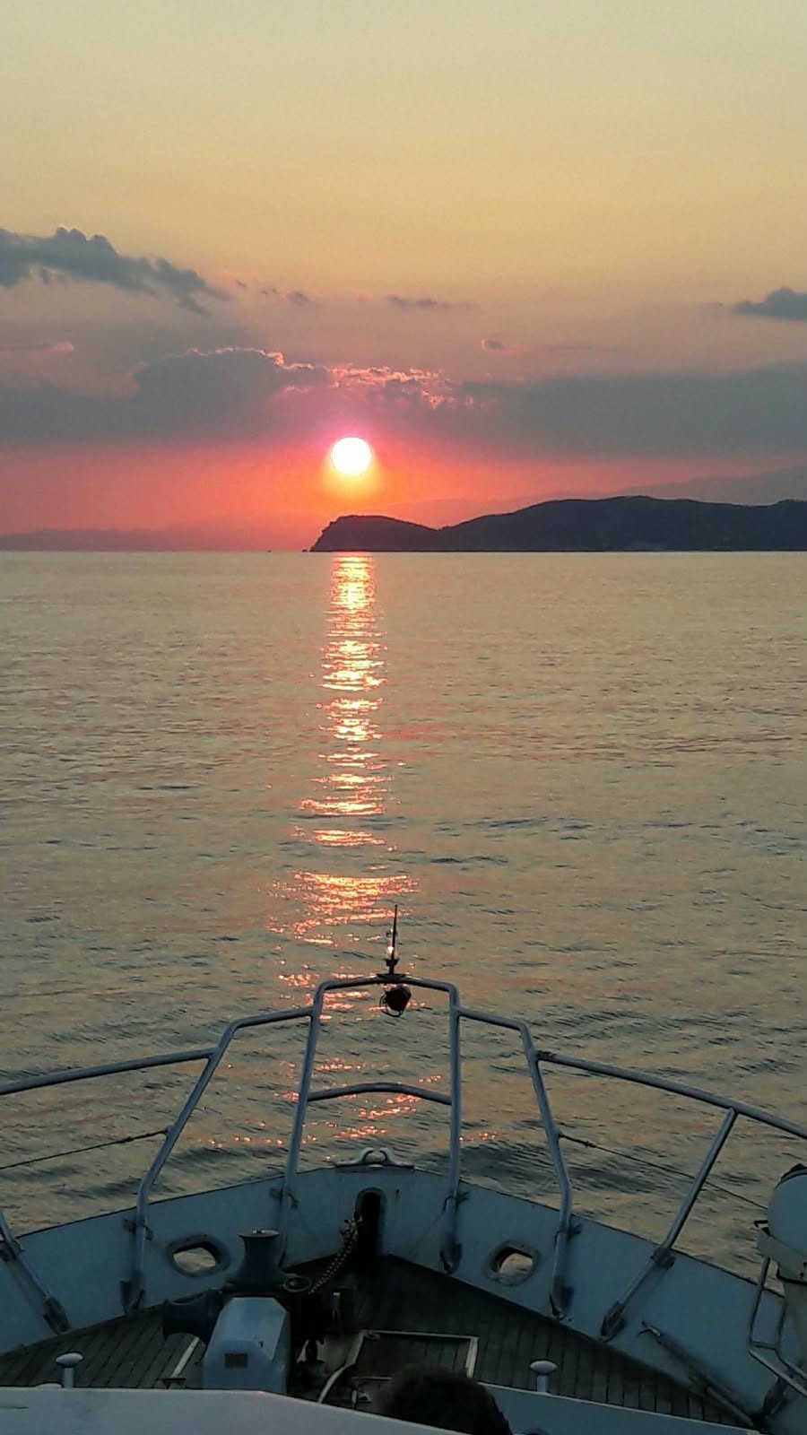 Sunset over the sea seen from the bow of the boat